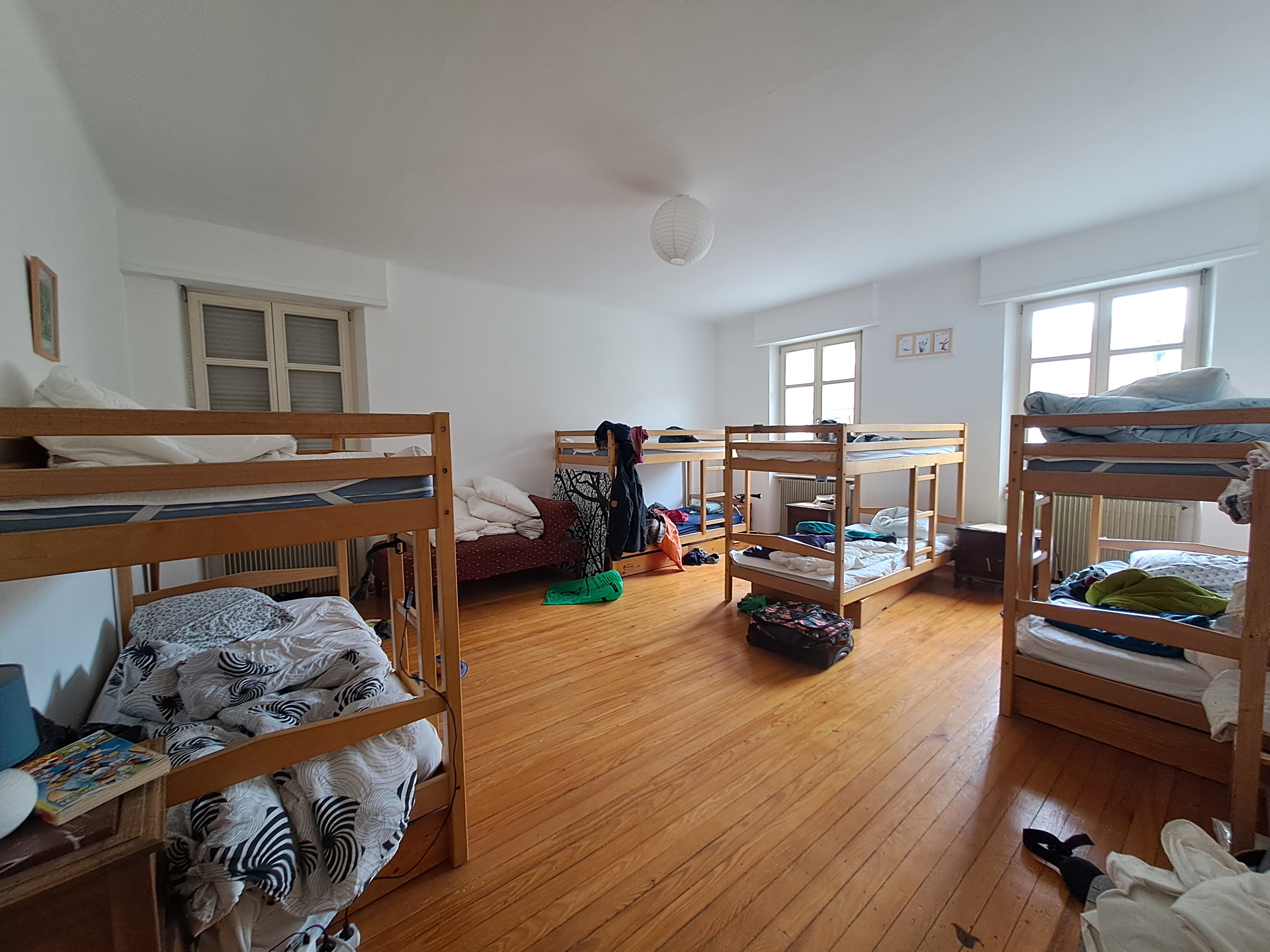 une dortoir composé de quatre lits superpsosés avec parquet et deux fenêtres