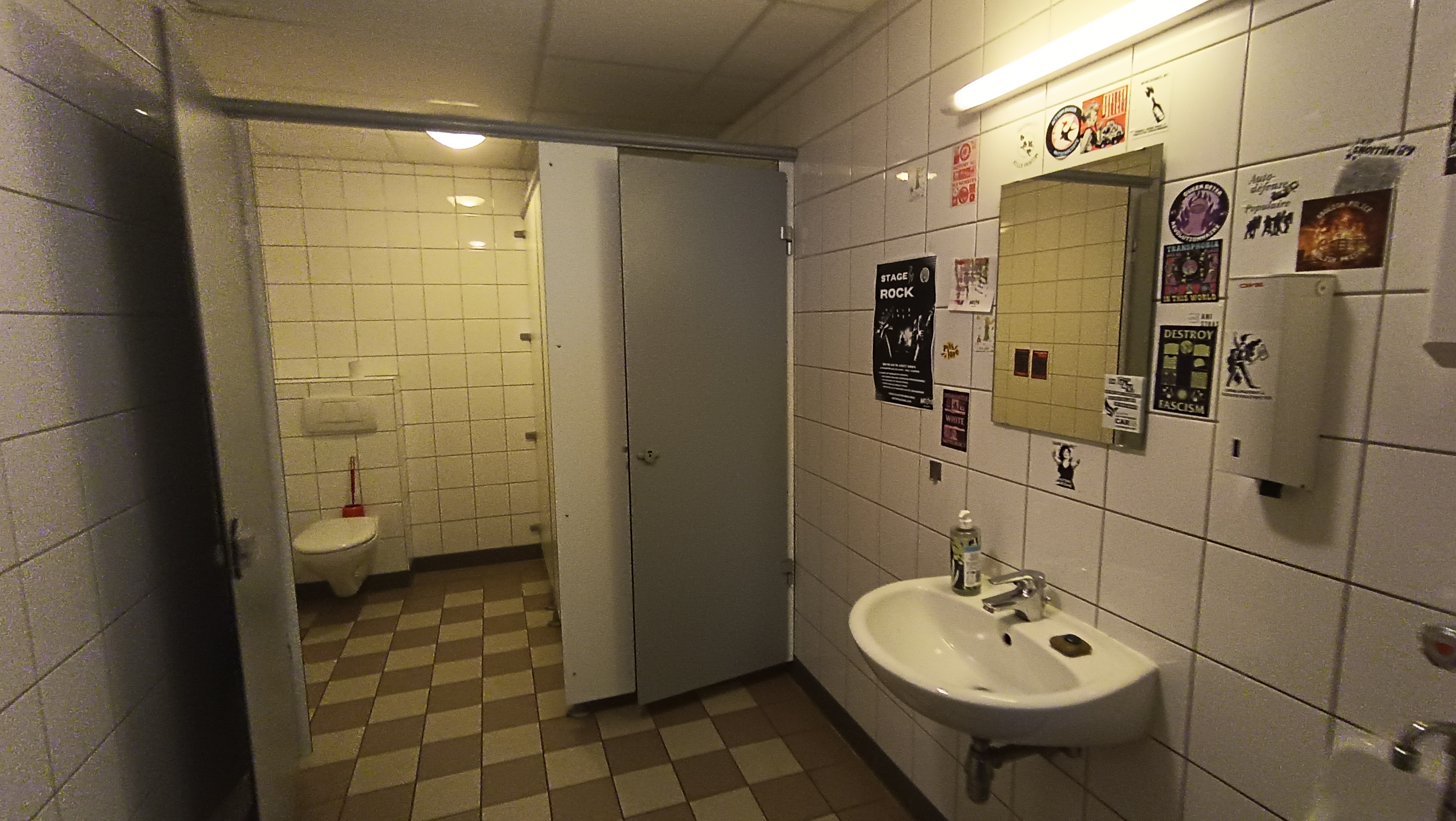 toilettes avec lavabo et une porte ouverte donnant sur un cabinet assis